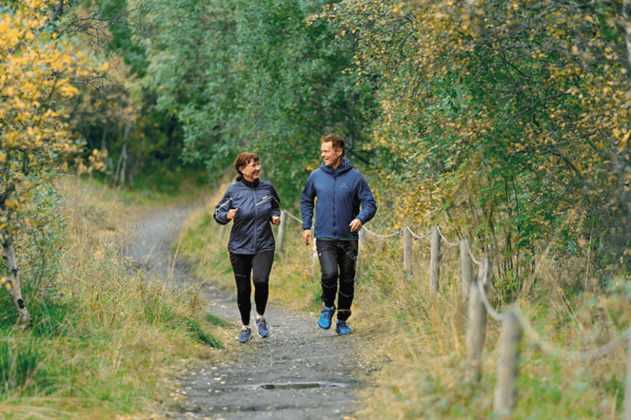 En dame og en mann som jogger på en sti.